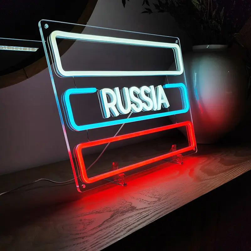 Nahaufnahme eines Neon-Schildes mit klarem Acryl-Hintergrund, das RUSSIA in Weiß mit hellblauen und roten Linien zeigt.