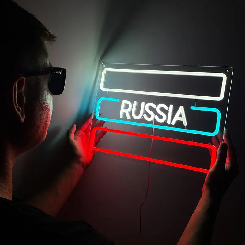 Flexibles LED-Neon-Schild mit dem Wort RUSSIA, beleuchtet in den russischen Flaggenfarben Weiß, Blau und Rot.