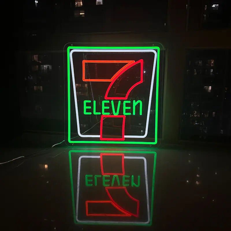 Retro-Leuchtreklame von 7-Eleven mit der typischen grünen Umrandung und der Zahl Sieben in Orange und Rot