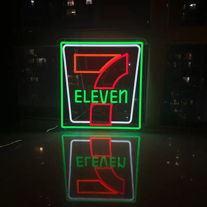 Retro-Leuchtreklame von 7-Eleven mit der typischen grünen Umrandung und der Zahl Sieben in Orange und Rot