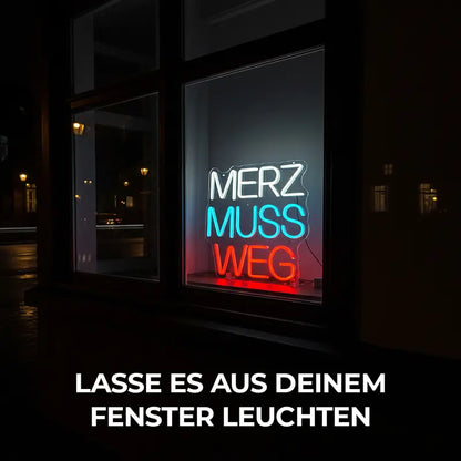 Wanddeko-Objekt mit politischem Kommentar, der Neon-Schriftzug "MERZ MUSS WEG" sticht mit seinen drei Farben hervor.