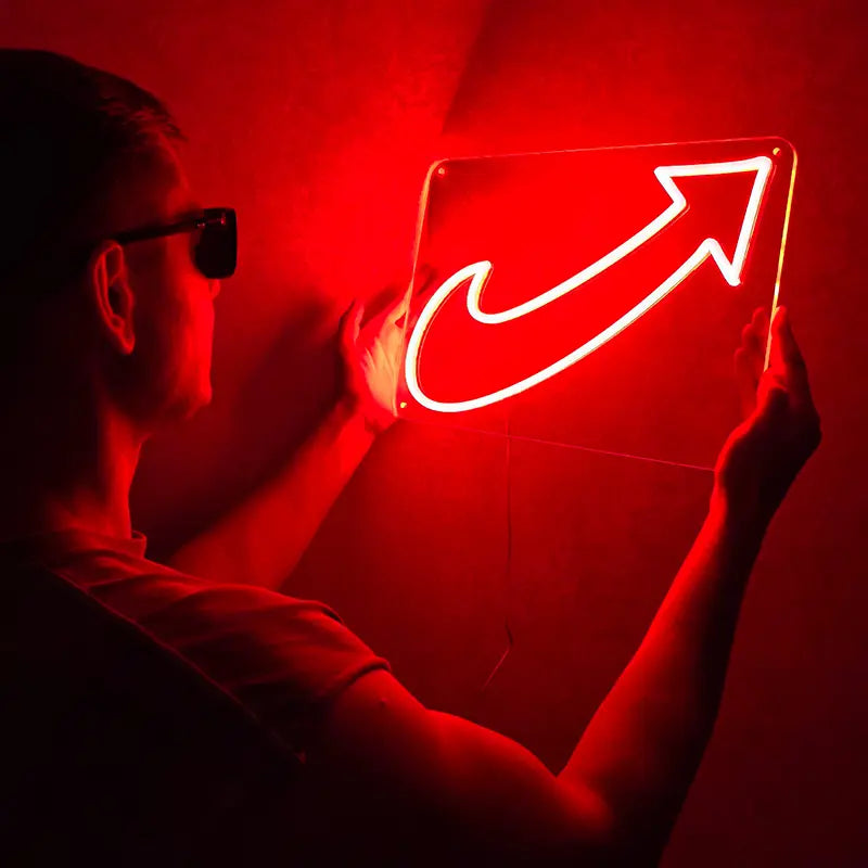 Streetwear-Ästhetik: Rote Neon-Beleuchtung mit einem dynamischen Haken-Pfeil-Symbol in dunkler Umgebung