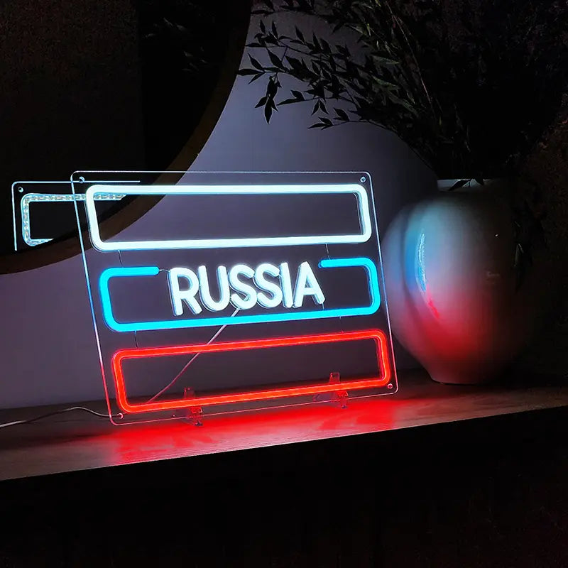 Deko-Leuchtschild für die Wand: RUSSLAND-Schriftzug in Neon-Optik mit weiß-blau-roter Umrandung.