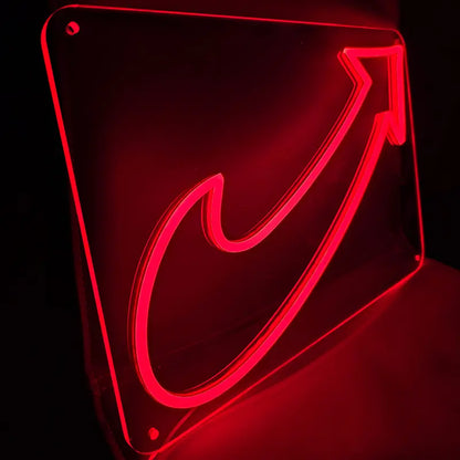 Nahaufnahme eines roten Neon-Logos, das einen Aufwärtspfeil darstellt, gehalten von einer Person im Schatten