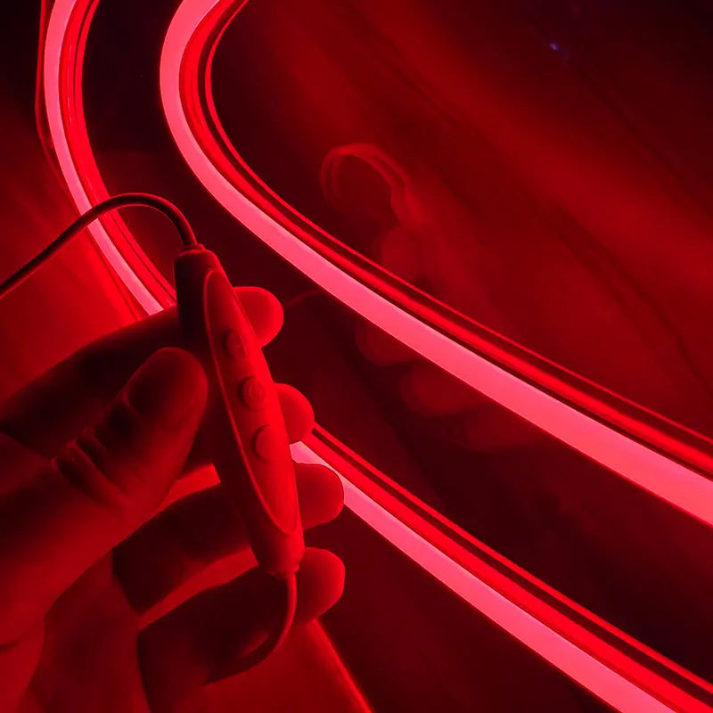 Leuchtendes LED-Kunstobjekt in Rot, das Dynamik und Fortschritt durch ein Pfeil-Symbol symbolisiert